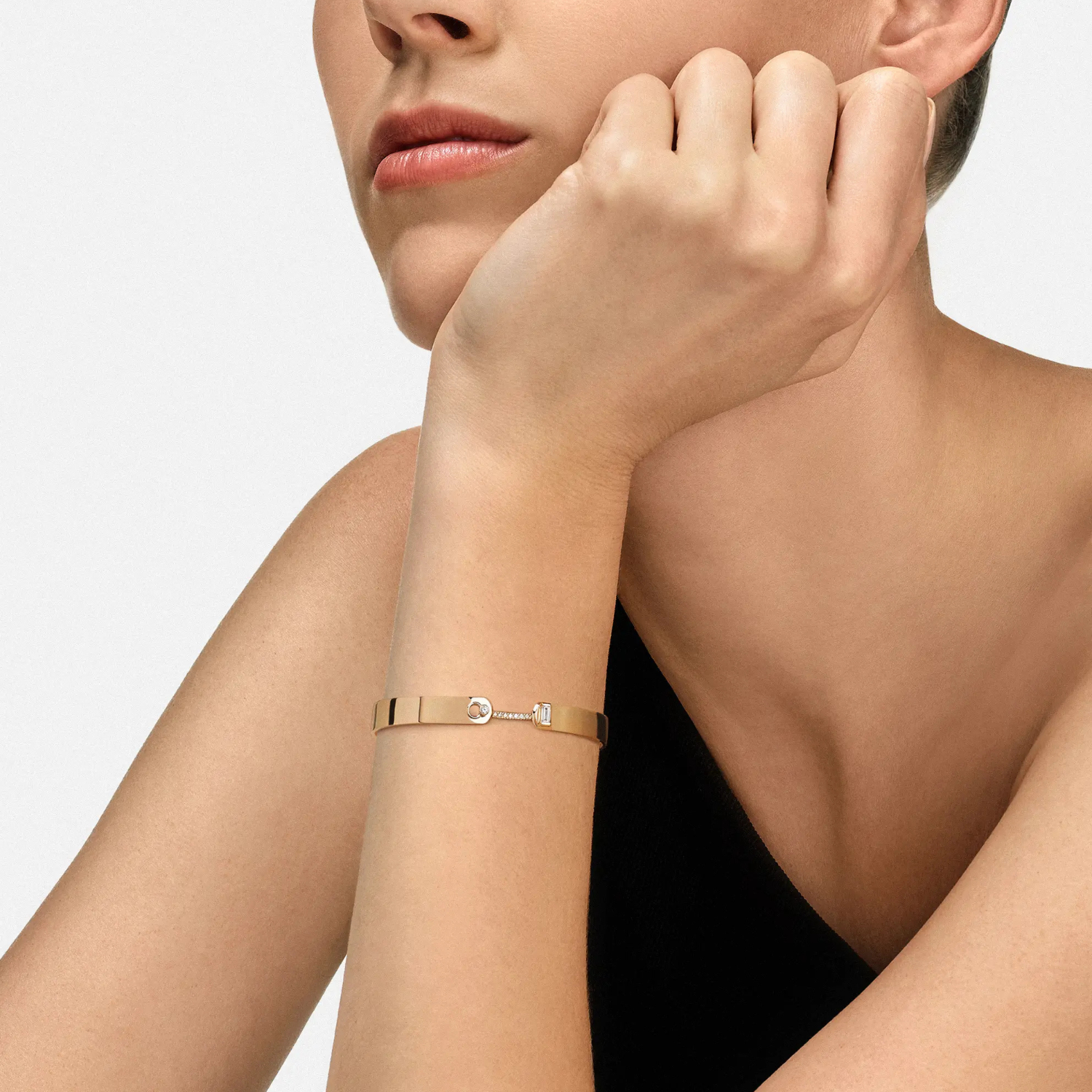 Woman wearing a rose gold bracelet on a neutral background